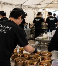 TEAM CAFE TOKYOスタッフが仮設厨房で衛生管理を行いながらイベントフードを調理する現場