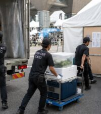 TEAM CAFE TOKYOスタッフが大型イベント会場で搬入車両から食材と保冷ボックスを荷下ろししバックヤードへ運ぶ様子