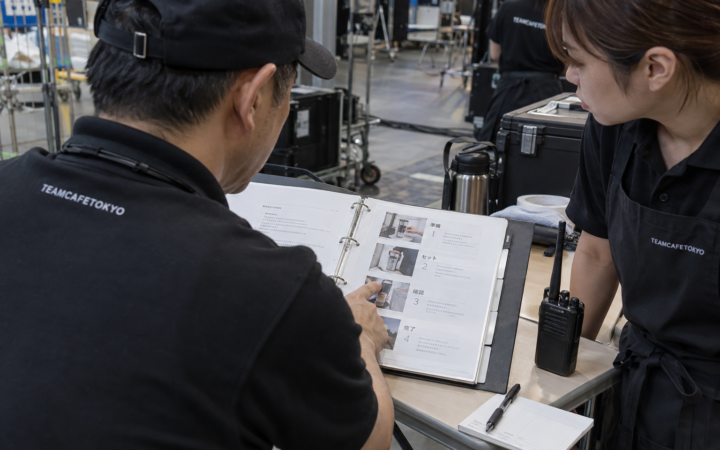 運営マニュアルと連絡手順を確認するスタッフ(AI生成イメージ)