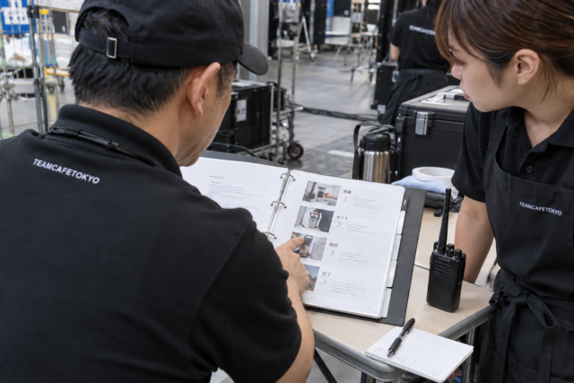 運営マニュアルと連絡手順を確認するスタッフ