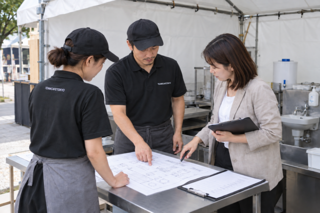 出店前に設備と確認書類を照合する担当者
